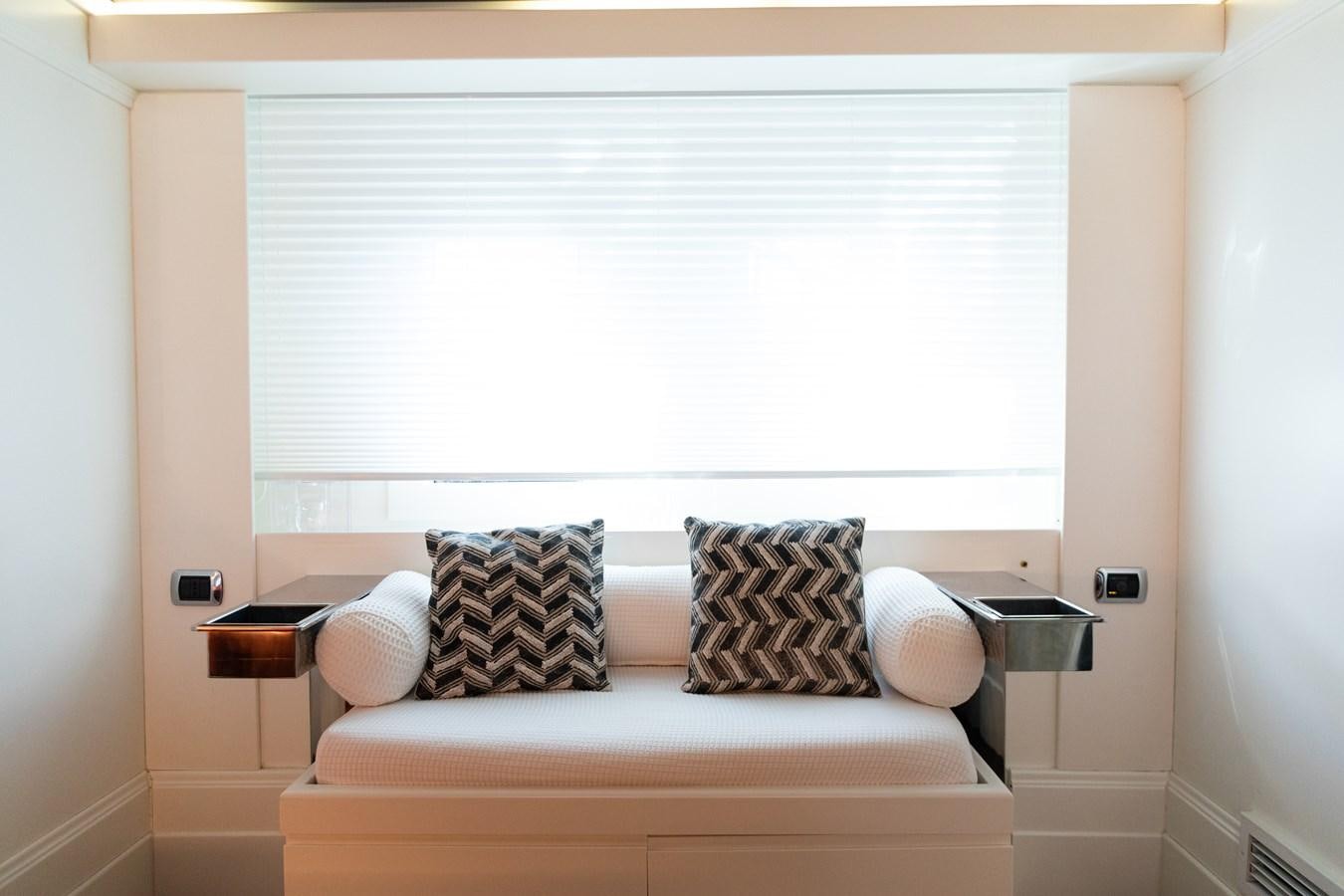 a bed with a chair and a window aboard VEVEKOS Yacht for Sale