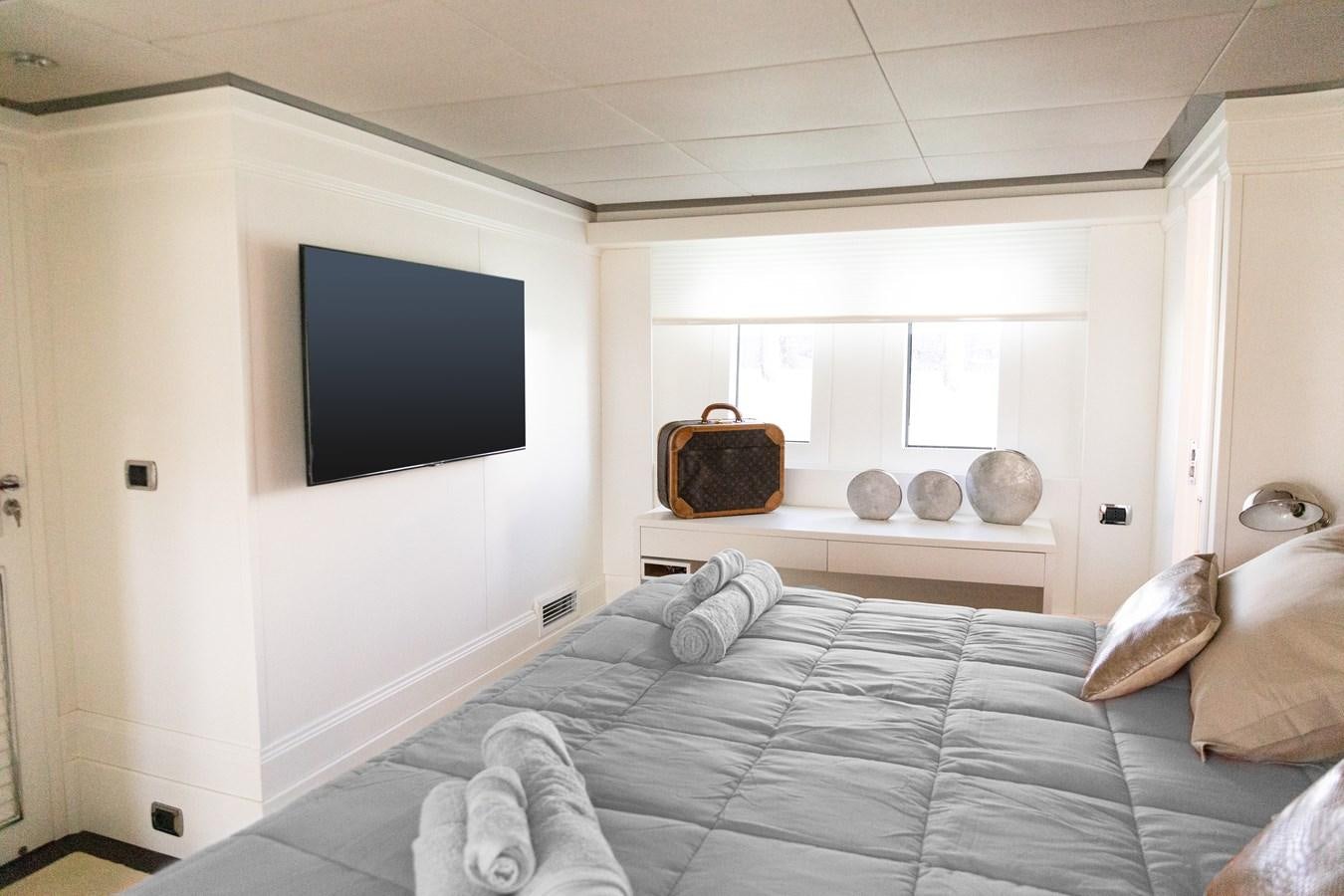 a bed with a television on the wall aboard VEVEKOS Yacht for Sale