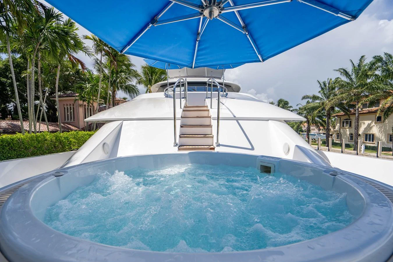 a pool with a ladder and a blue umbrella aboard SEAQUEST Yacht for Sale