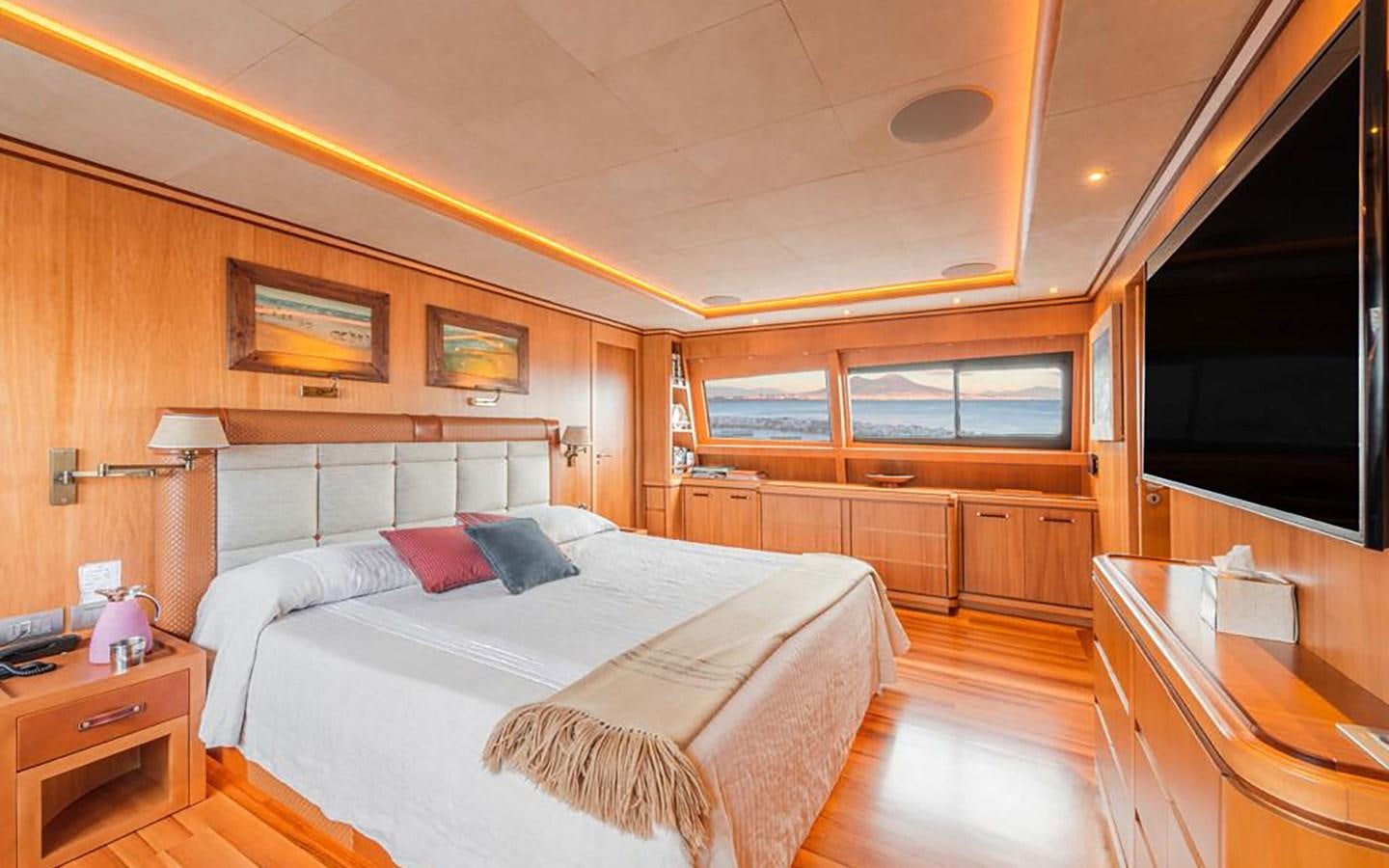 a bedroom with a bed and a desk aboard ANGRA TOO Yacht for Sale