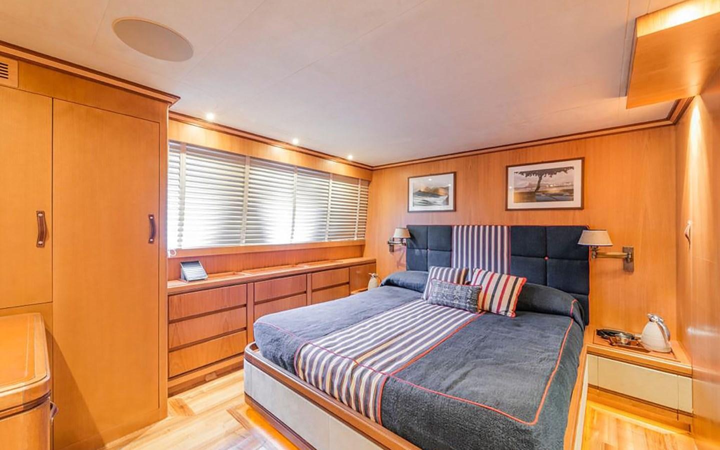a bedroom with a bed and a desk aboard ANGRA TOO Yacht for Sale