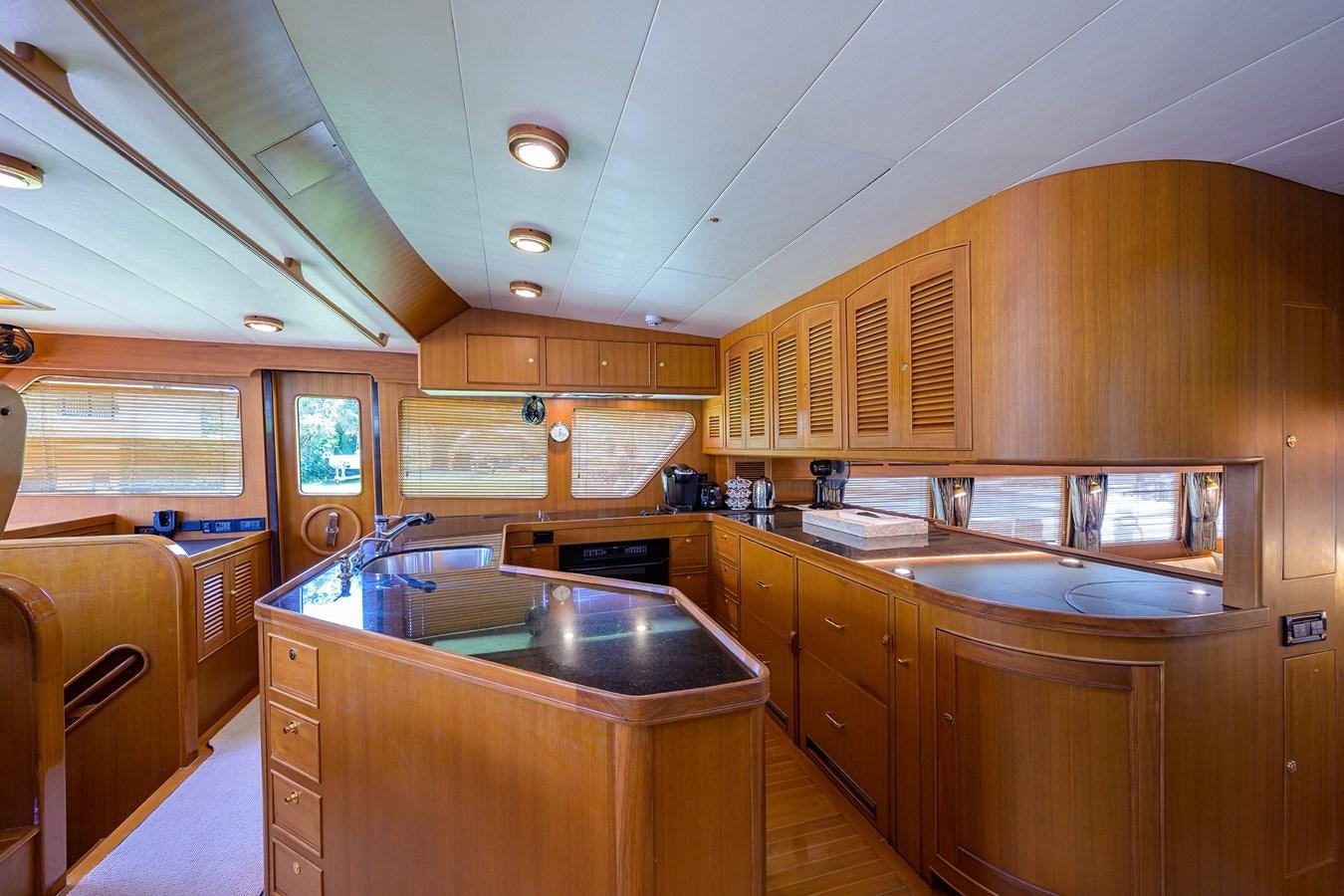 a kitchen with wooden cabinets aboard BELLA Yacht for Sale