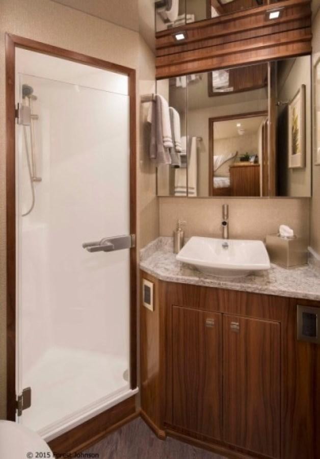 a bathroom with a sink and a mirror aboard NEW VIKING 80 ENCLOSED BRIDGE Yacht for Sale