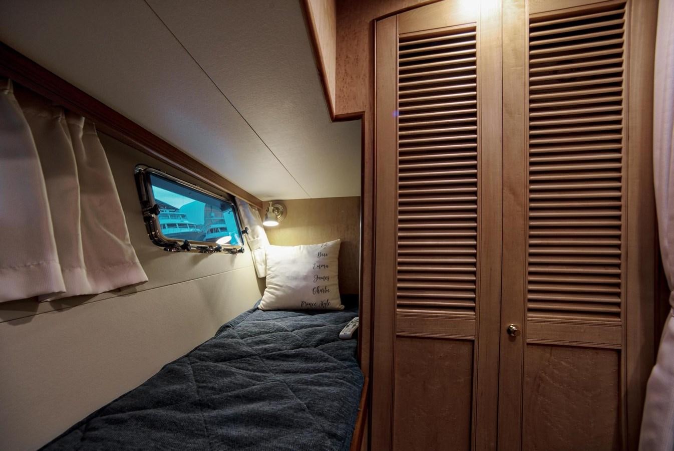 a bed with a blue bed spread aboard BEN'S BARGE Yacht for Sale