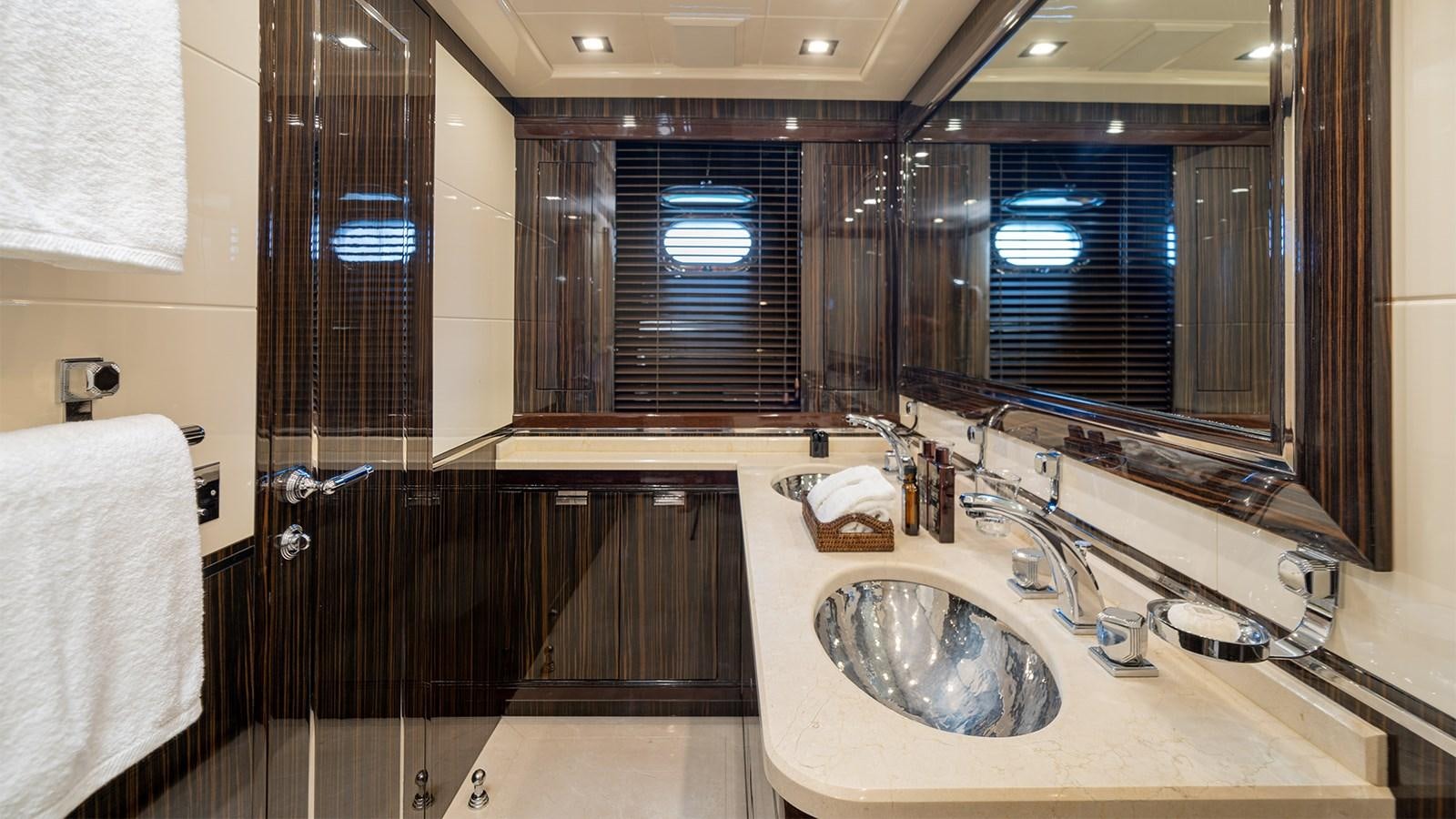 a bathroom with a sink and a large mirror aboard DEVA I Yacht for Sale