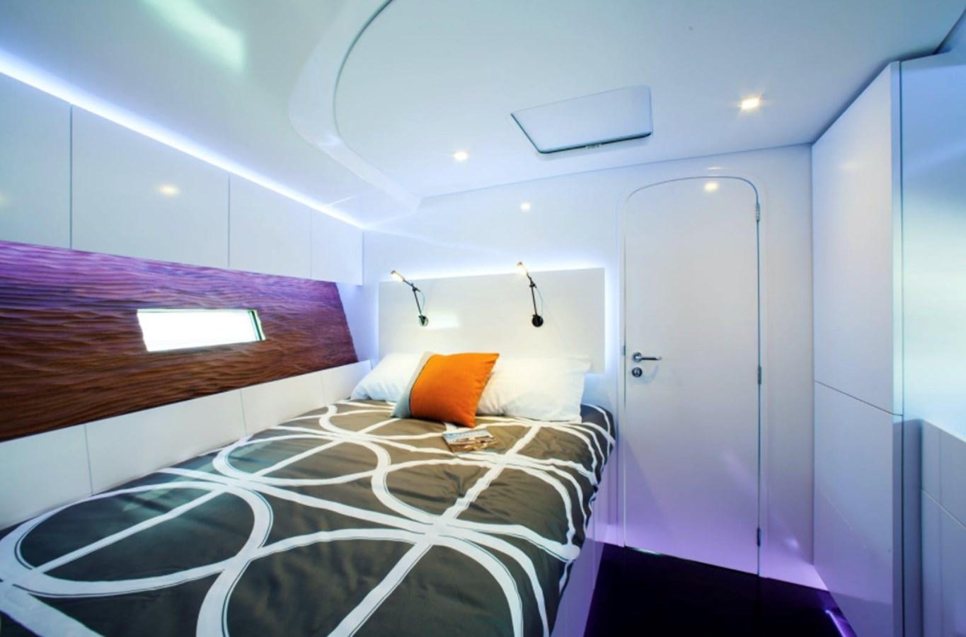 a bed with a white sheet and orange pillows aboard AANDEEL Yacht for Sale