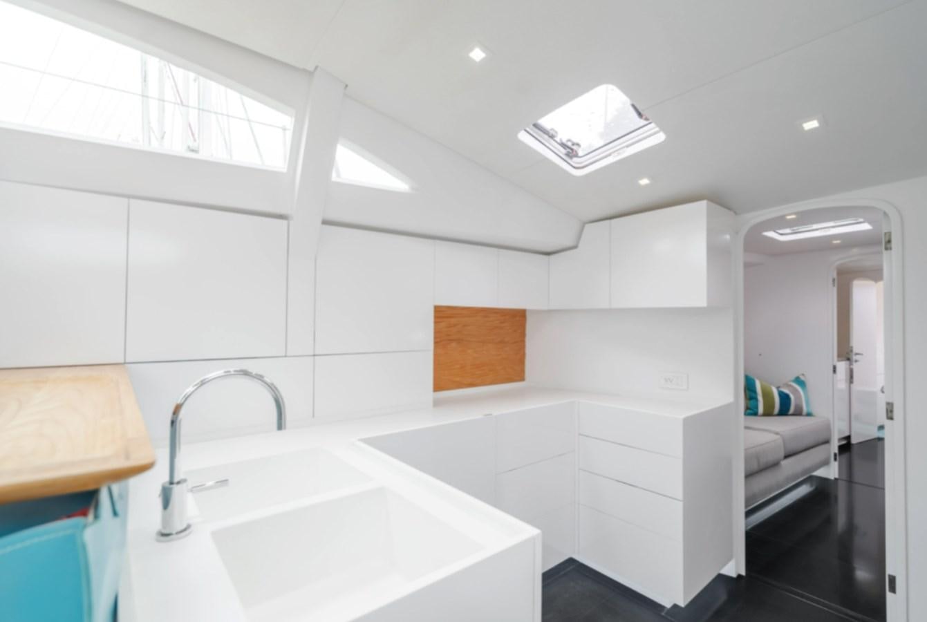 a white bathroom with a sink and a bed aboard AANDEEL Yacht for Sale