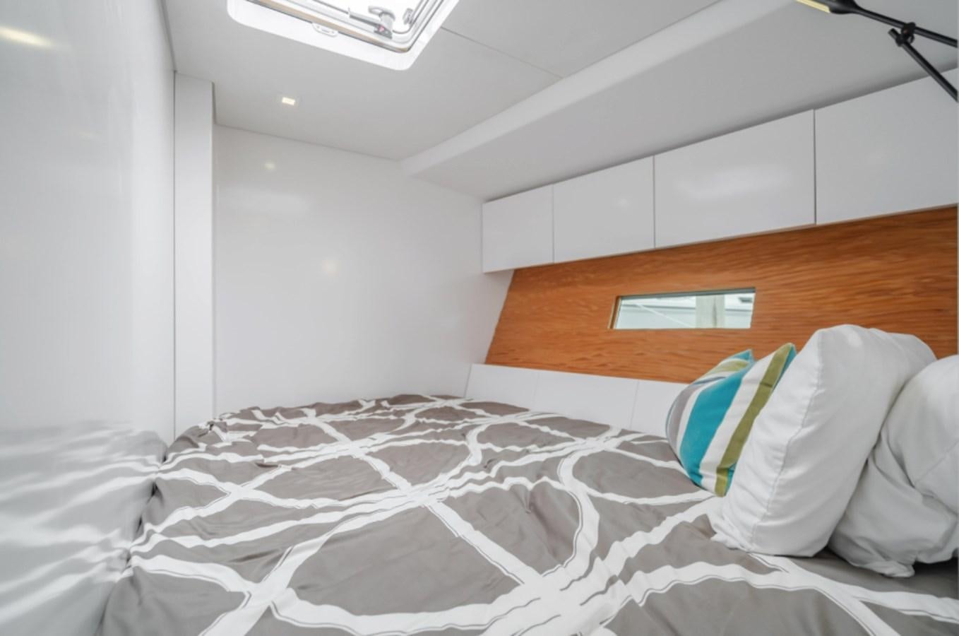 a bed with a white sheet and a blue and white pillow aboard AANDEEL Yacht for Sale