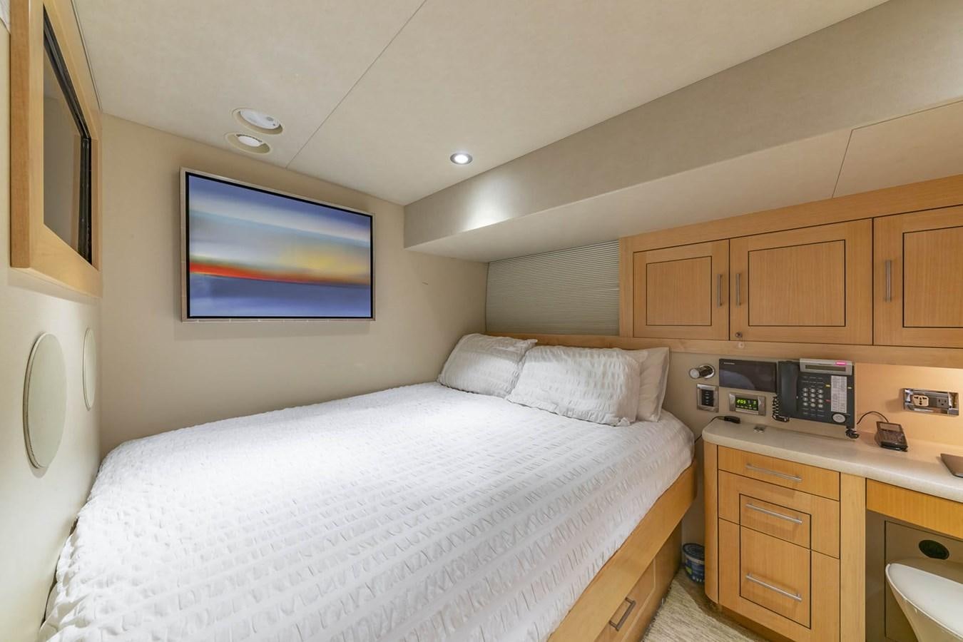 a bedroom with a bed and a desk aboard SIMPLICITY Yacht for Sale