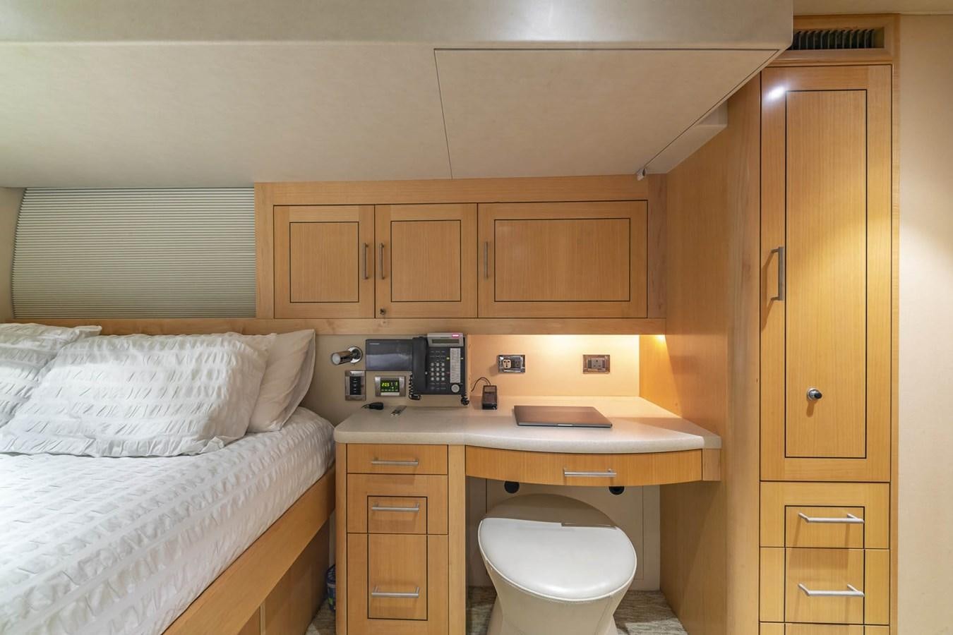 a small bedroom with a bed and desk aboard SIMPLICITY Yacht for Sale