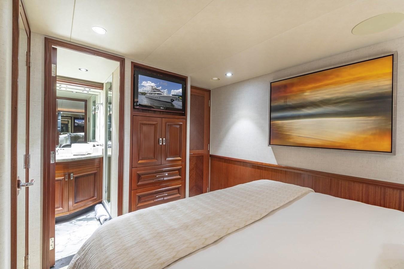 a bedroom with a bed and a television on the wall aboard SIMPLICITY Yacht for Sale