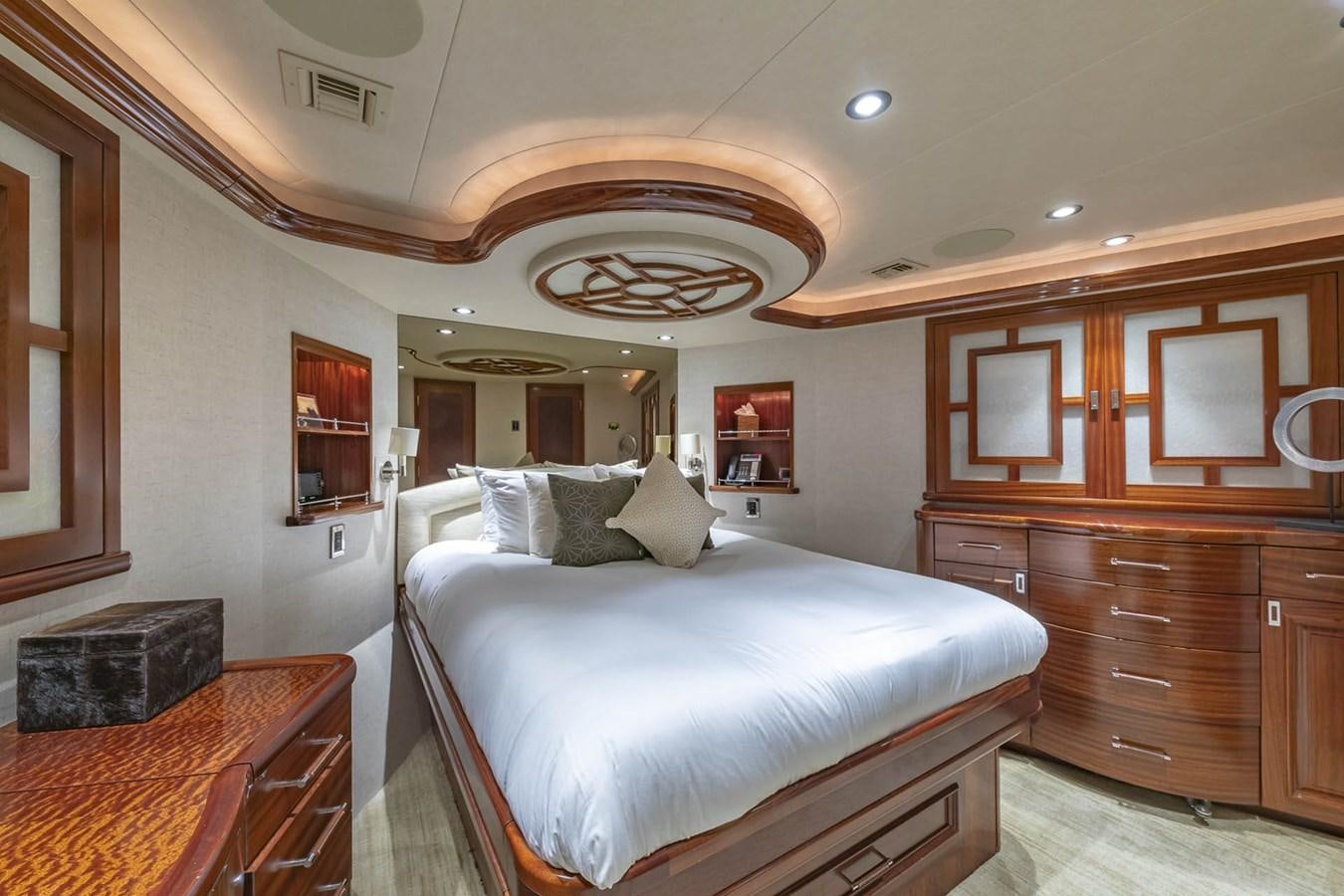 a bedroom with a bed and a dresser aboard SIMPLICITY Yacht for Sale