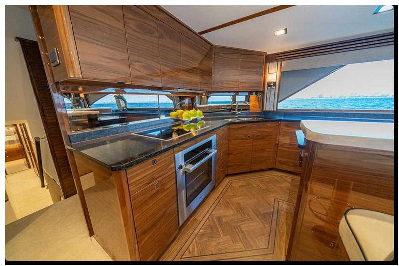 a kitchen with wooden cabinets aboard NEW VIKING 90 SKYBRIDGE Yacht for Sale