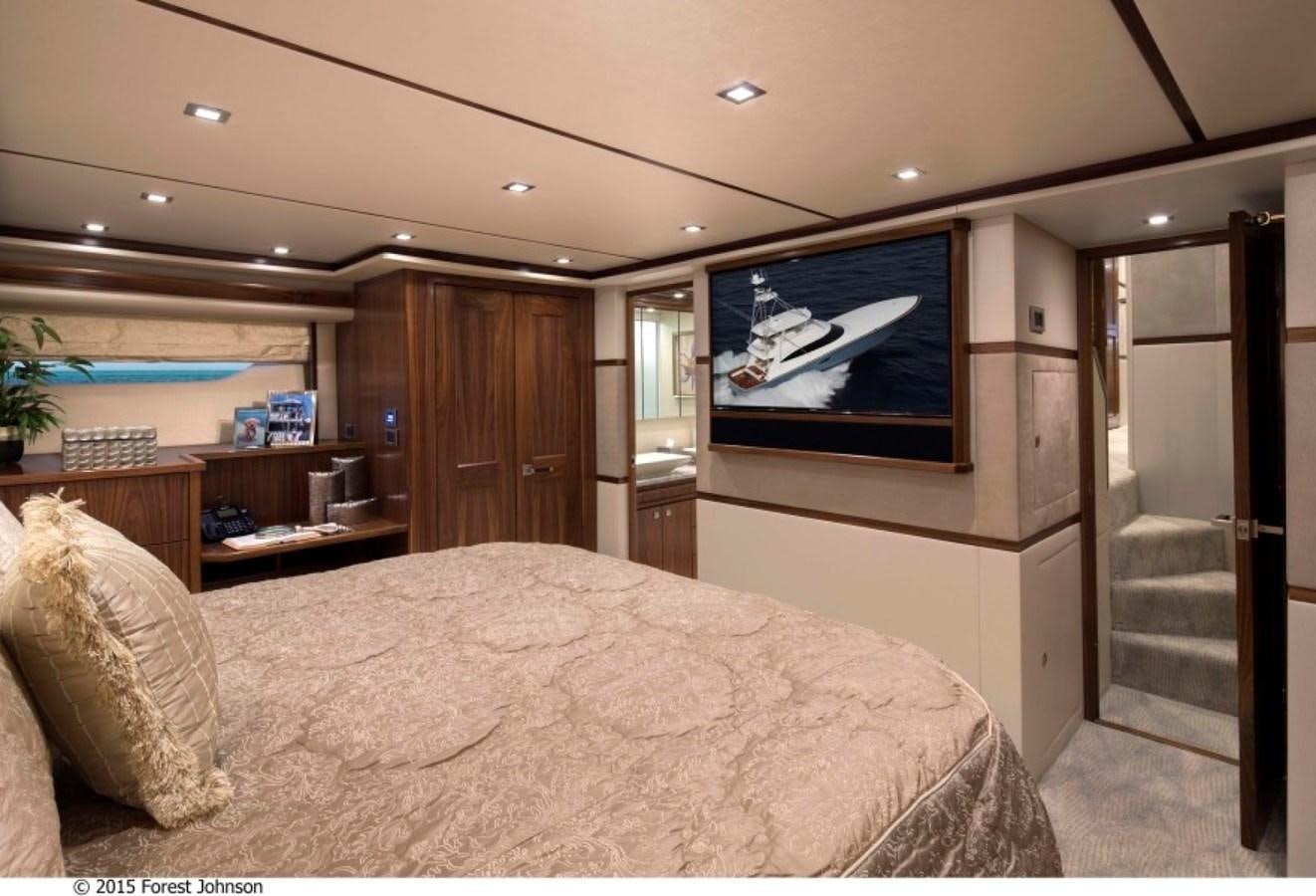 a bedroom with a bed and a television on the wall aboard NEW VIKING 80 SKYBRIDGE Yacht for Sale