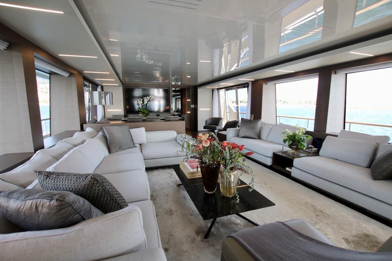 a living room with white couches and a coffee table aboard WILLPOWER Yacht for Sale