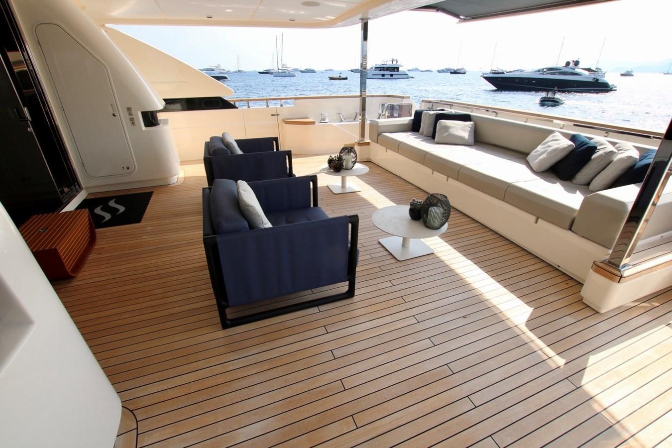a room with a couch and a table and a boat in the water aboard WILLPOWER Yacht for Sale