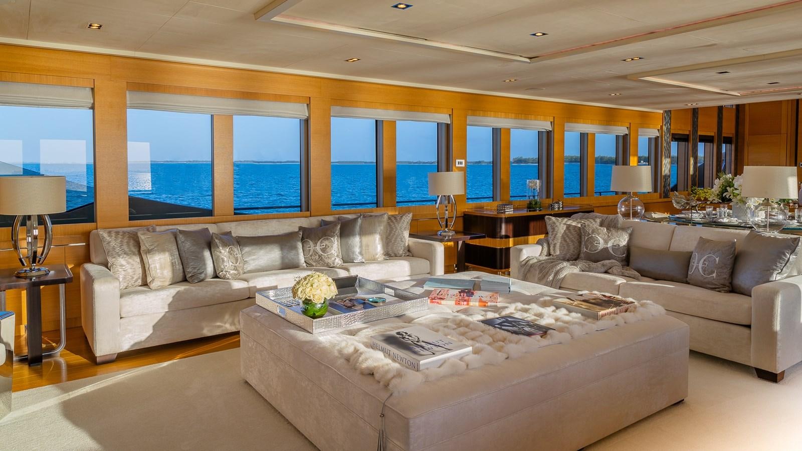 a living room with a large sectional sofa and a large window aboard DB9 Yacht for Charter
