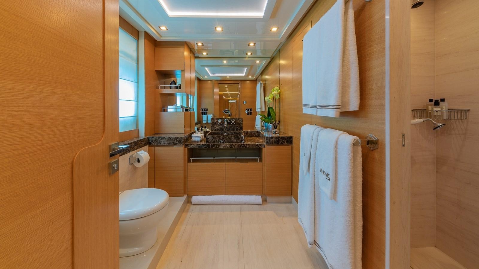 a bathroom with a sink toilet and towels aboard DB9 Yacht for Charter