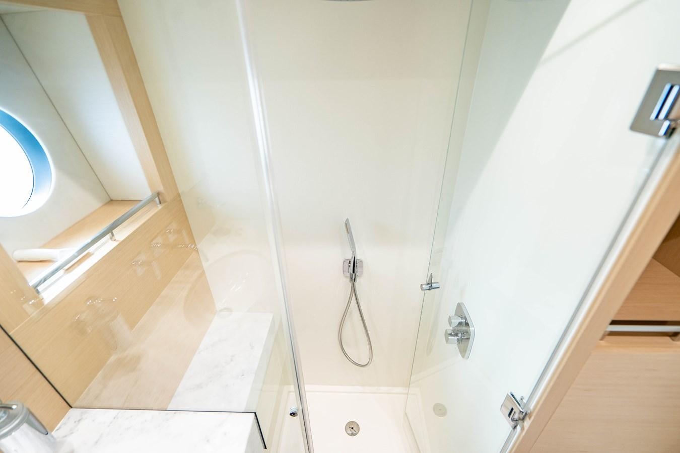 a white bathroom with a glass door aboard SUBMARINO Yacht for Sale
