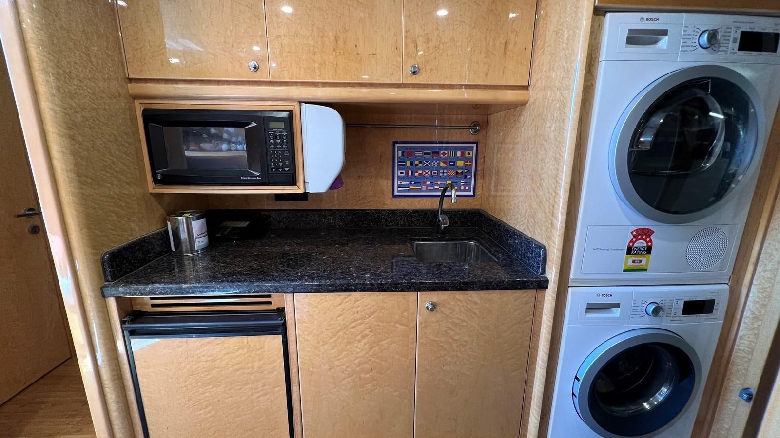 a kitchen with a washing machine and washer aboard MISSY B II Yacht for Sale