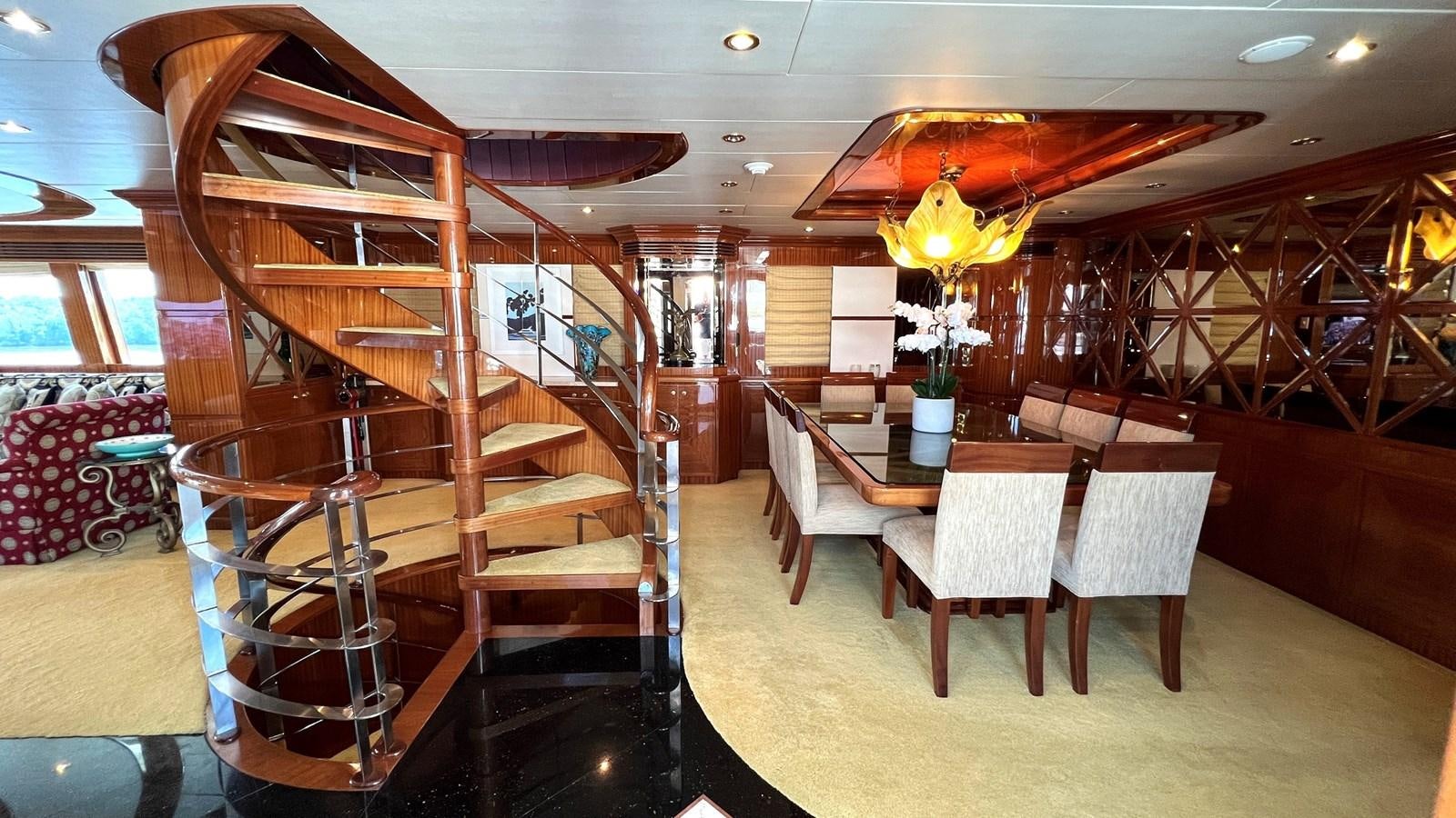 a room with a staircase and tables aboard MISSY B II Yacht for Sale