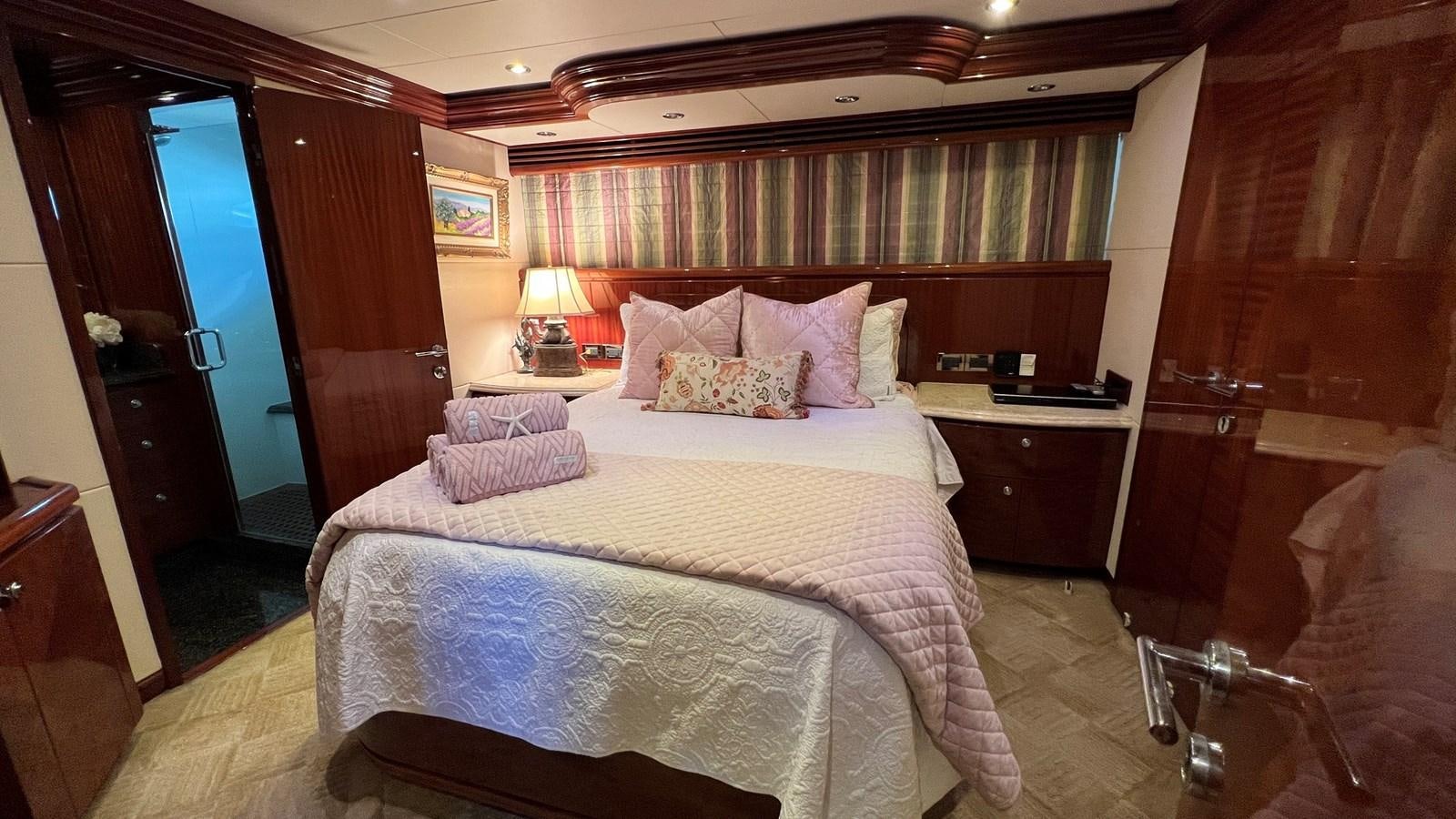 a bedroom with a bed and a chair aboard MISSY B II Yacht for Sale