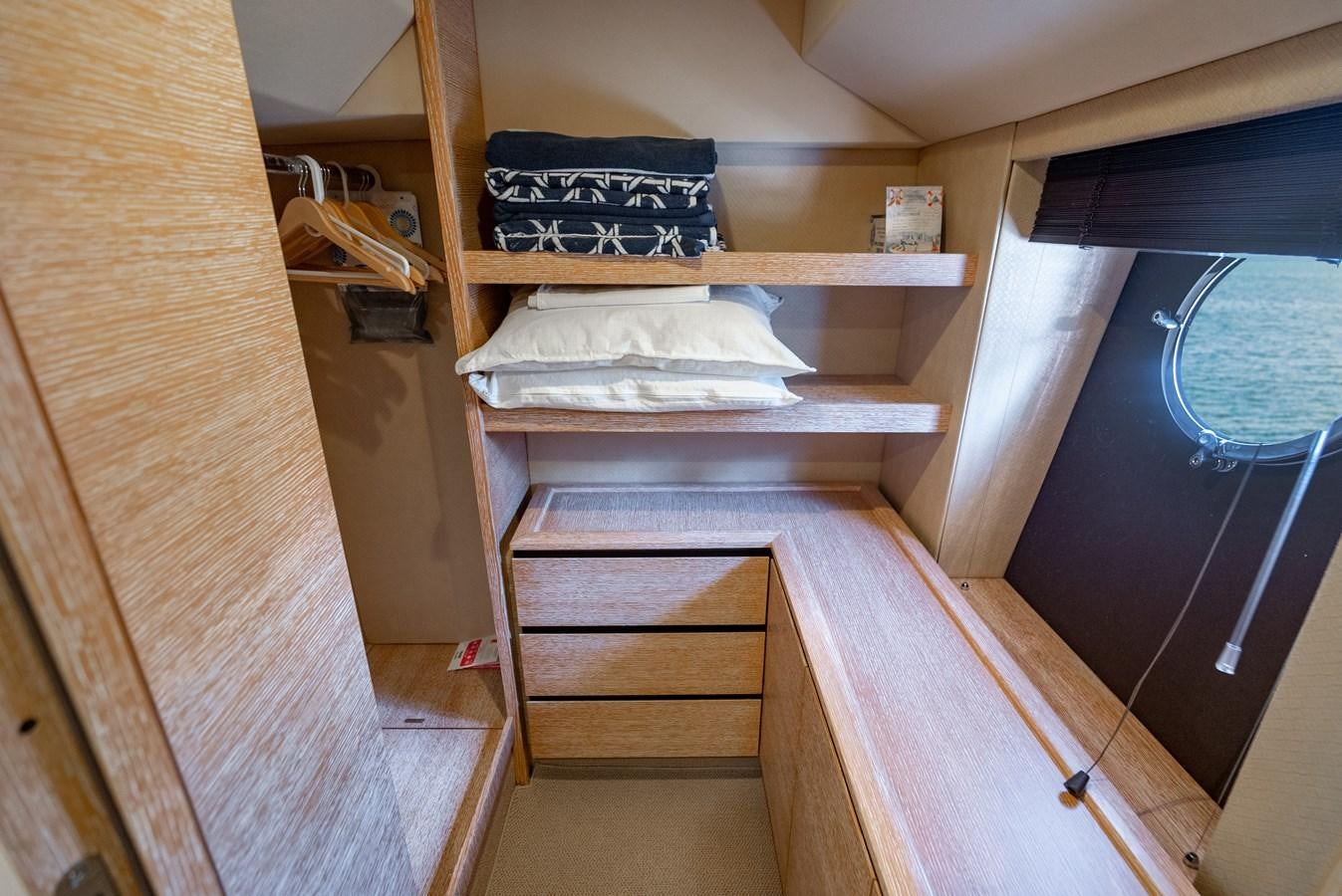 a bunk bed with a shelf of books on it aboard DAYS LIKE THIS Yacht for Sale