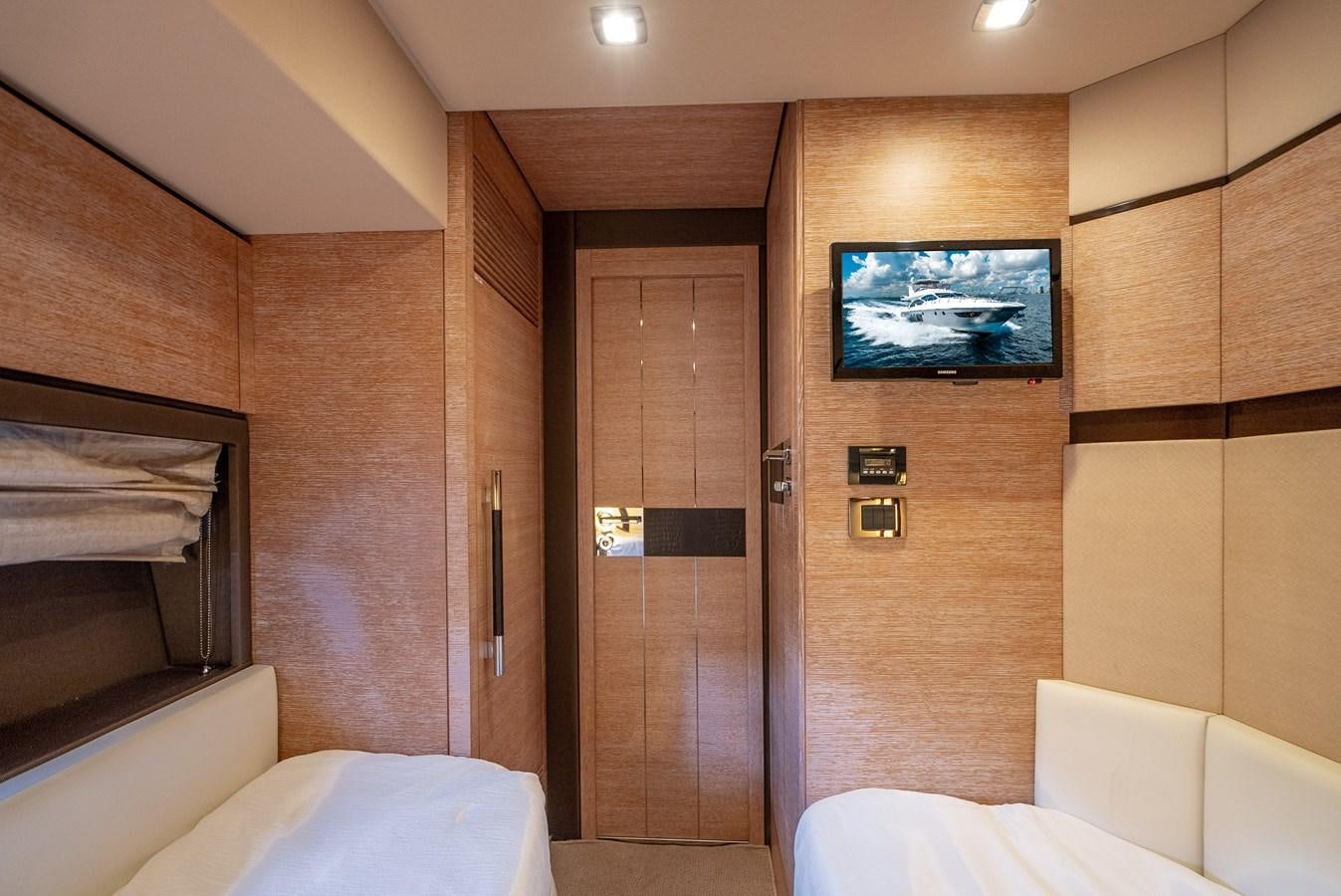 a room with a bed and a television on the wall aboard DAYS LIKE THIS Yacht for Sale