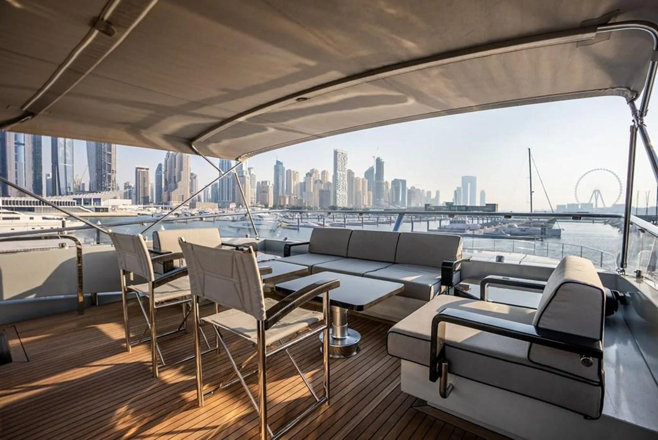 a boat deck with chairs and a city skyline in the background aboard HIGH ROLLER Yacht for Sale