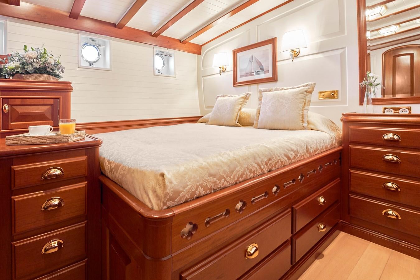 a bedroom with a bed and a dresser aboard ELENA OF LONDON Yacht for Sale