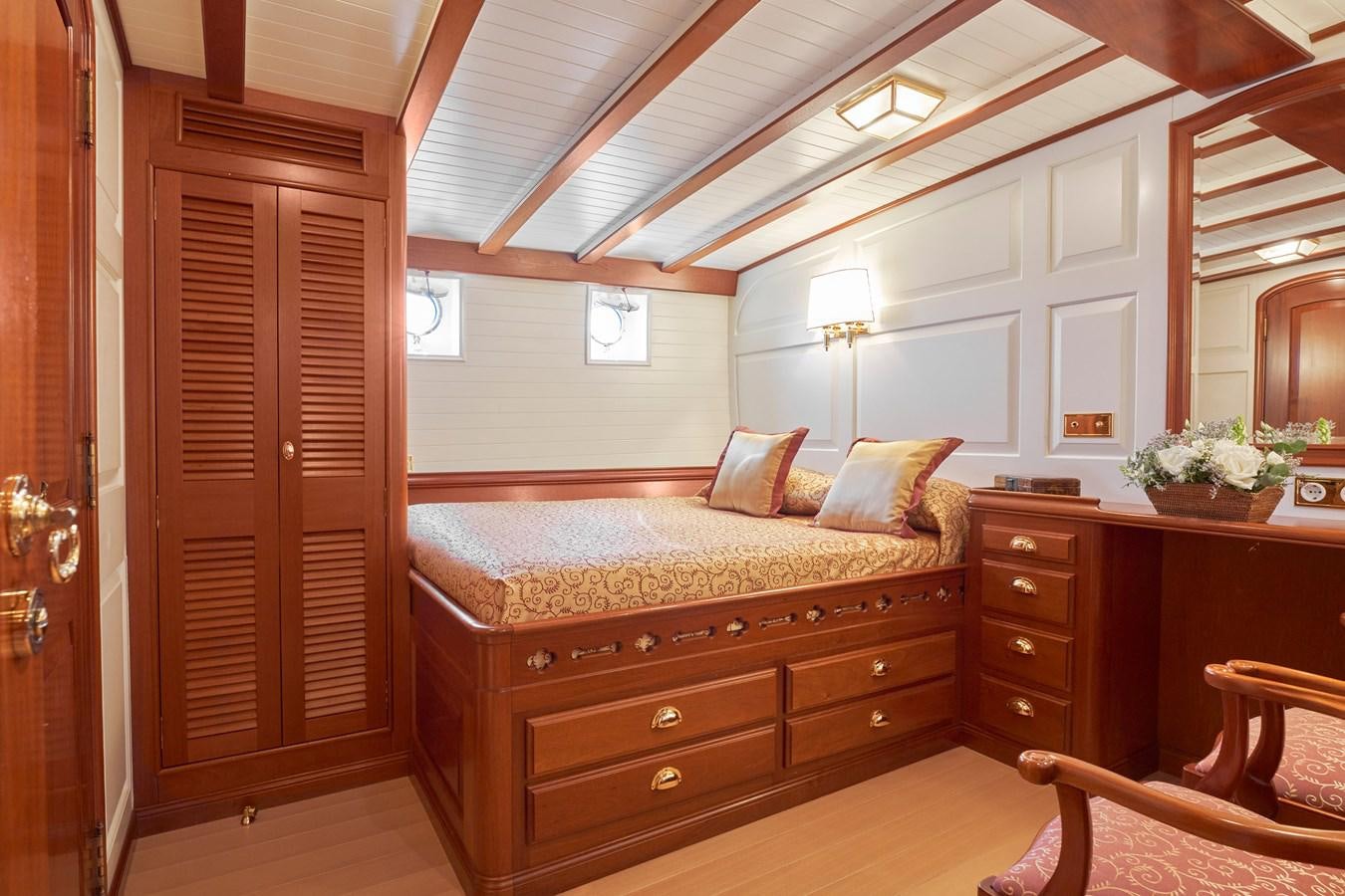 a bedroom with a bed and a desk aboard ELENA OF LONDON Yacht for Sale