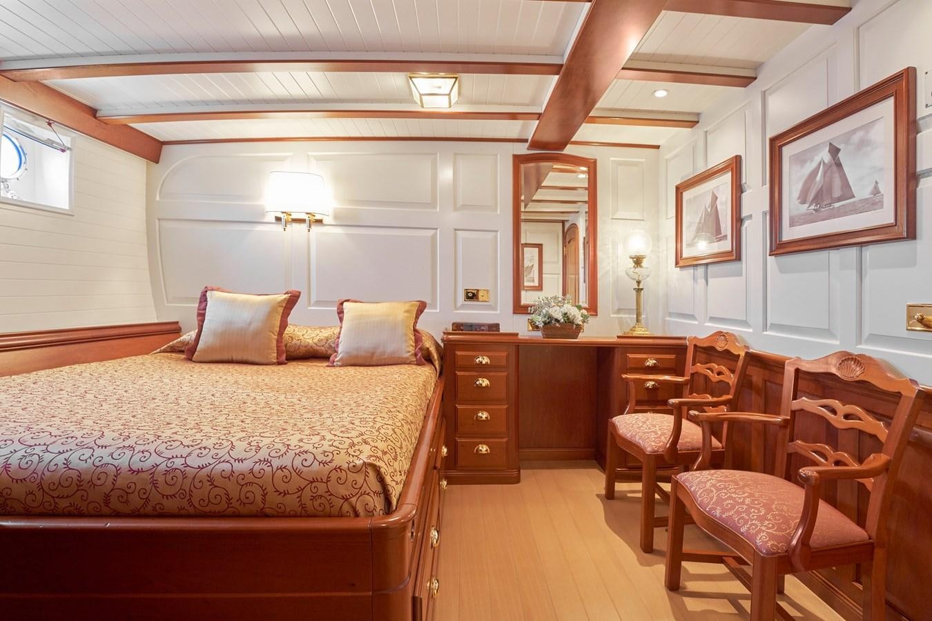 a bedroom with a bed and a desk aboard ELENA OF LONDON Yacht for Sale