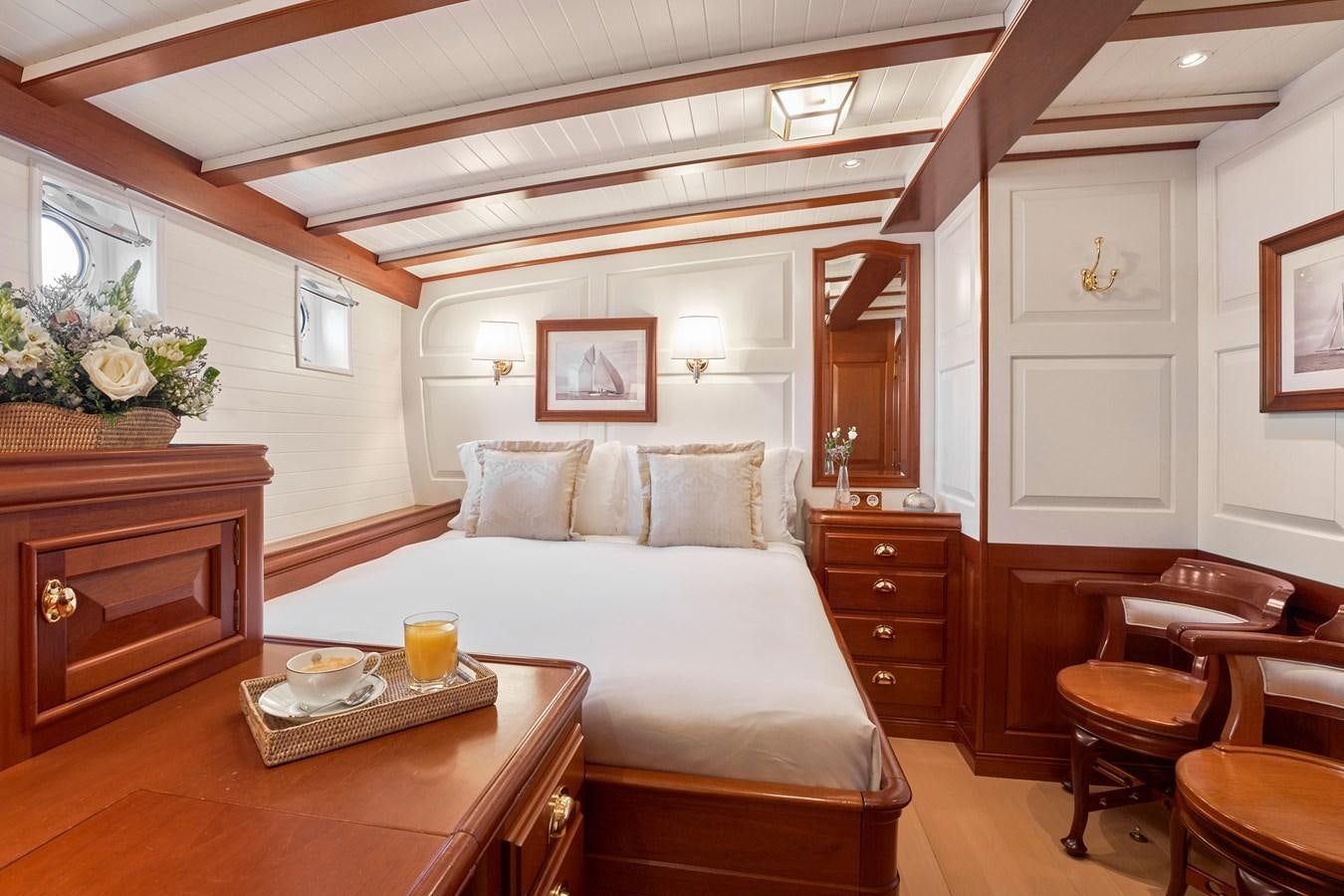 a bed and a table in a room aboard ELENA OF LONDON Yacht for Sale