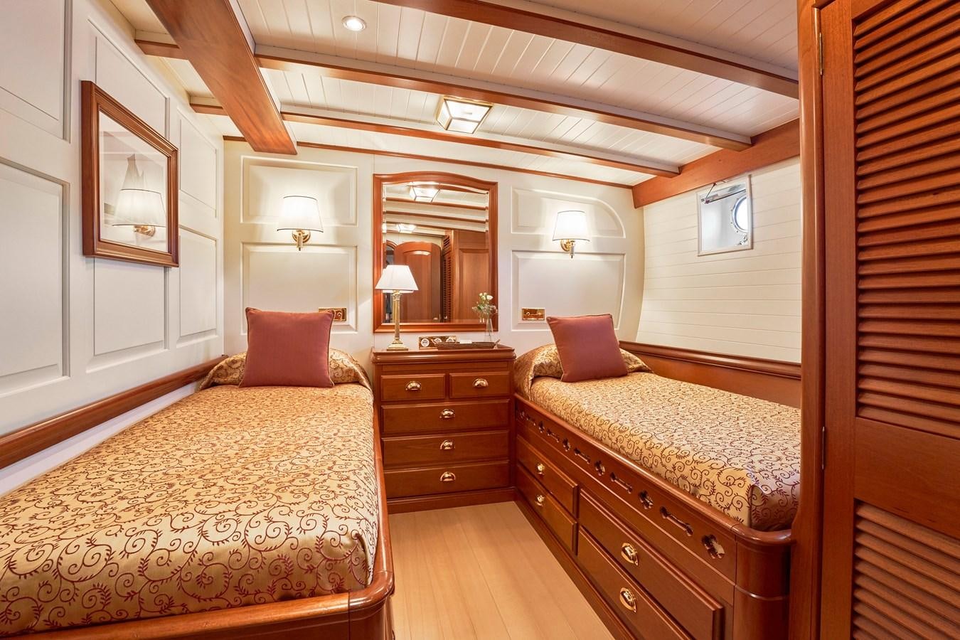 a bedroom with a bed and a dresser aboard ELENA OF LONDON Yacht for Sale