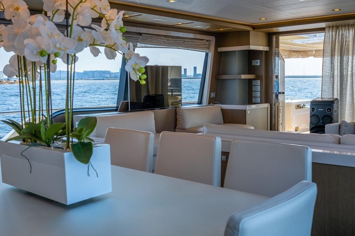a room with a couch and a table with chairs and a plant aboard FERRETTI 870 Yacht for Sale