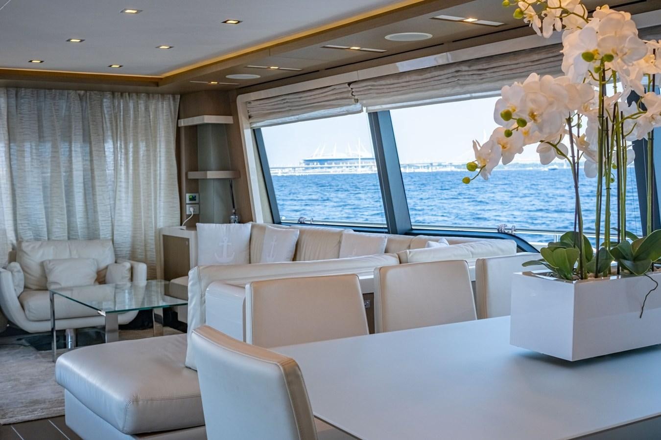 a room with a large window and a table with chairs and a large pool of water aboard FERRETTI 870 Yacht for Sale
