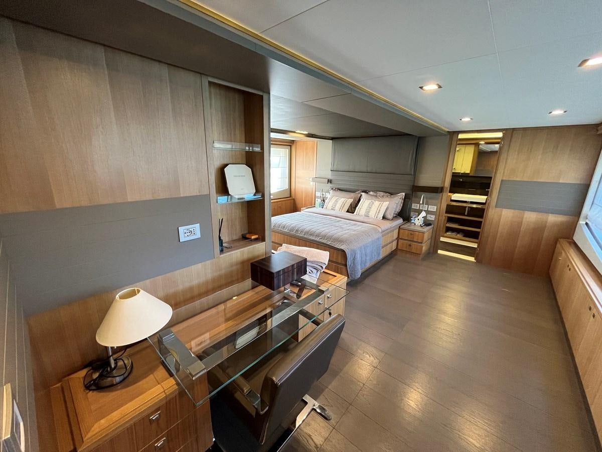 a hotel room with a bed and desk aboard SELF Yacht for Sale