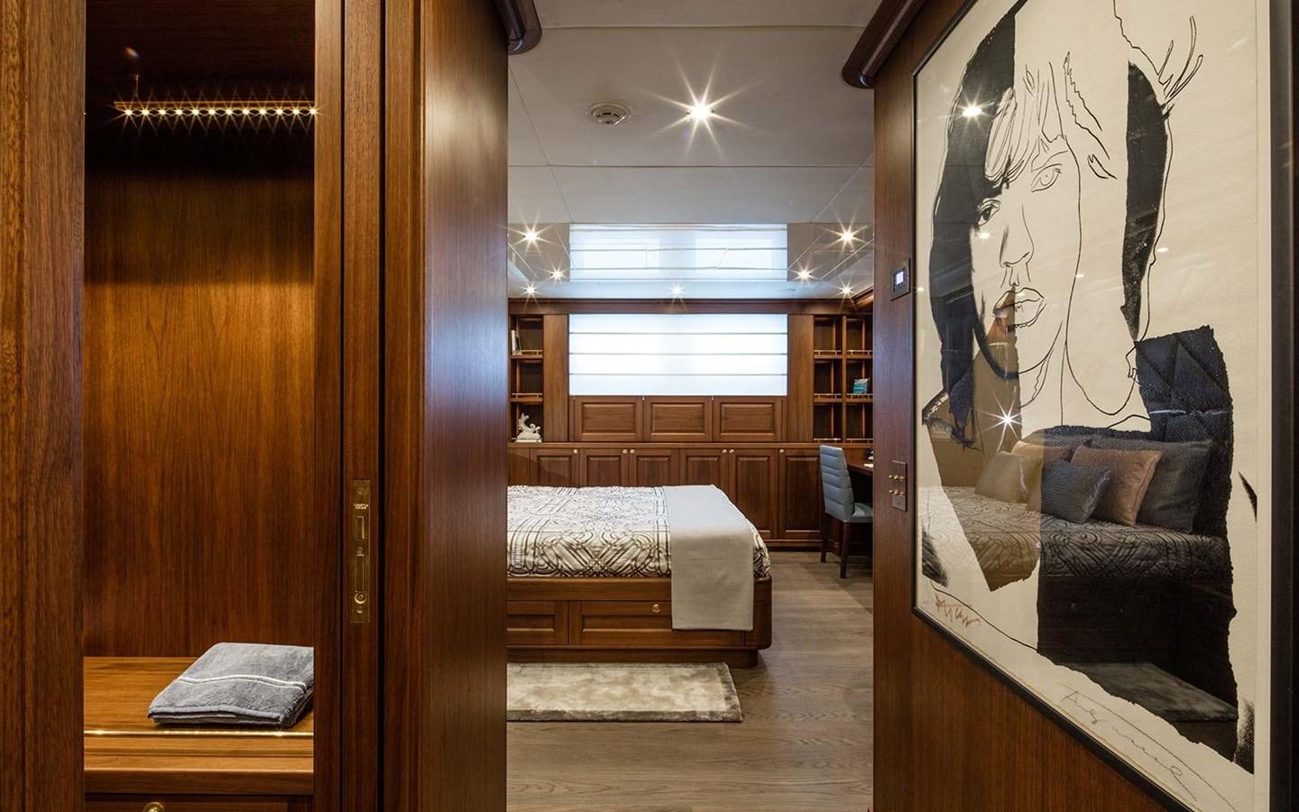 a bedroom with a bed and a painting aboard ATLAS Yacht for Sale