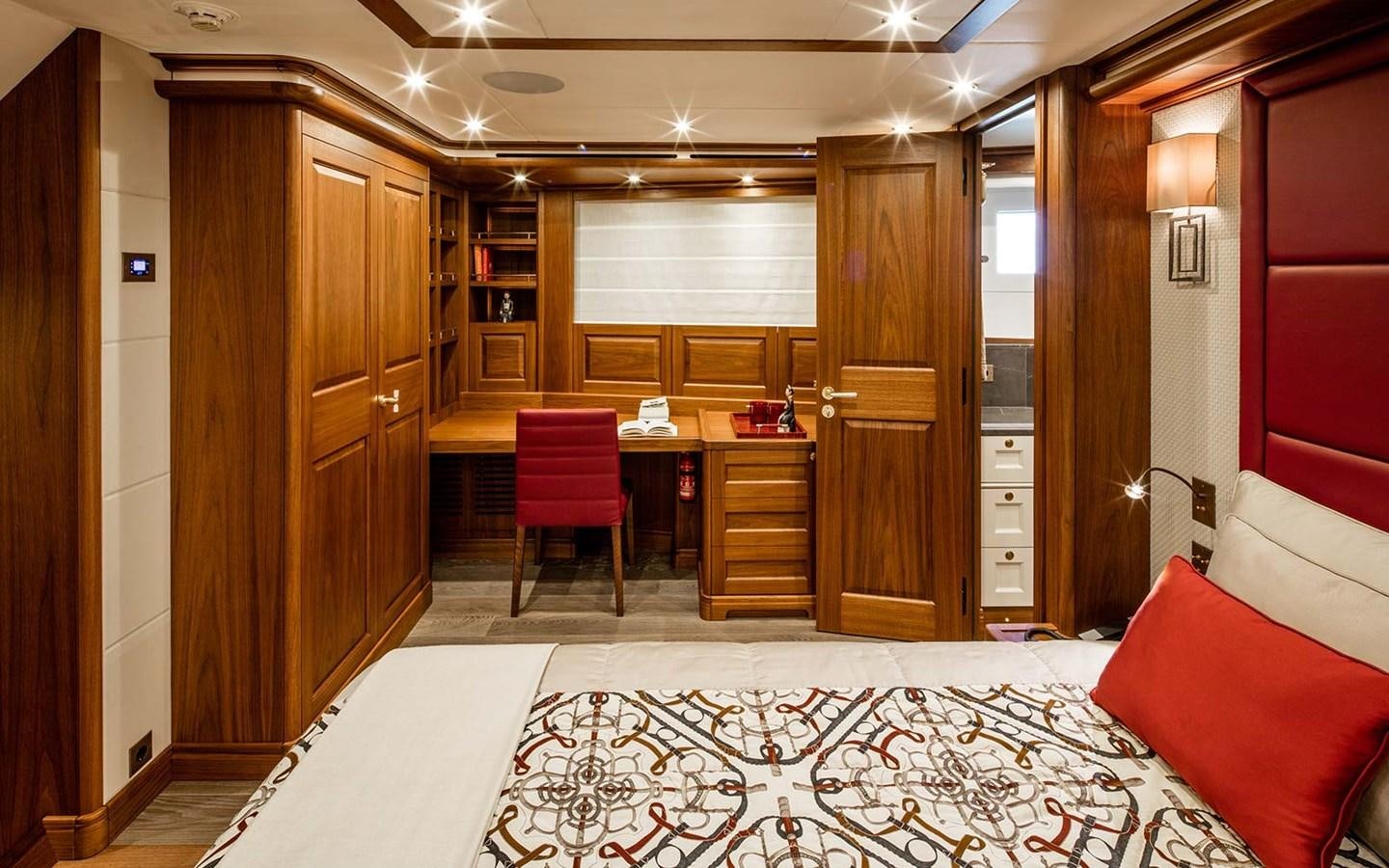 a room with a bed and desk aboard ATLAS Yacht for Sale