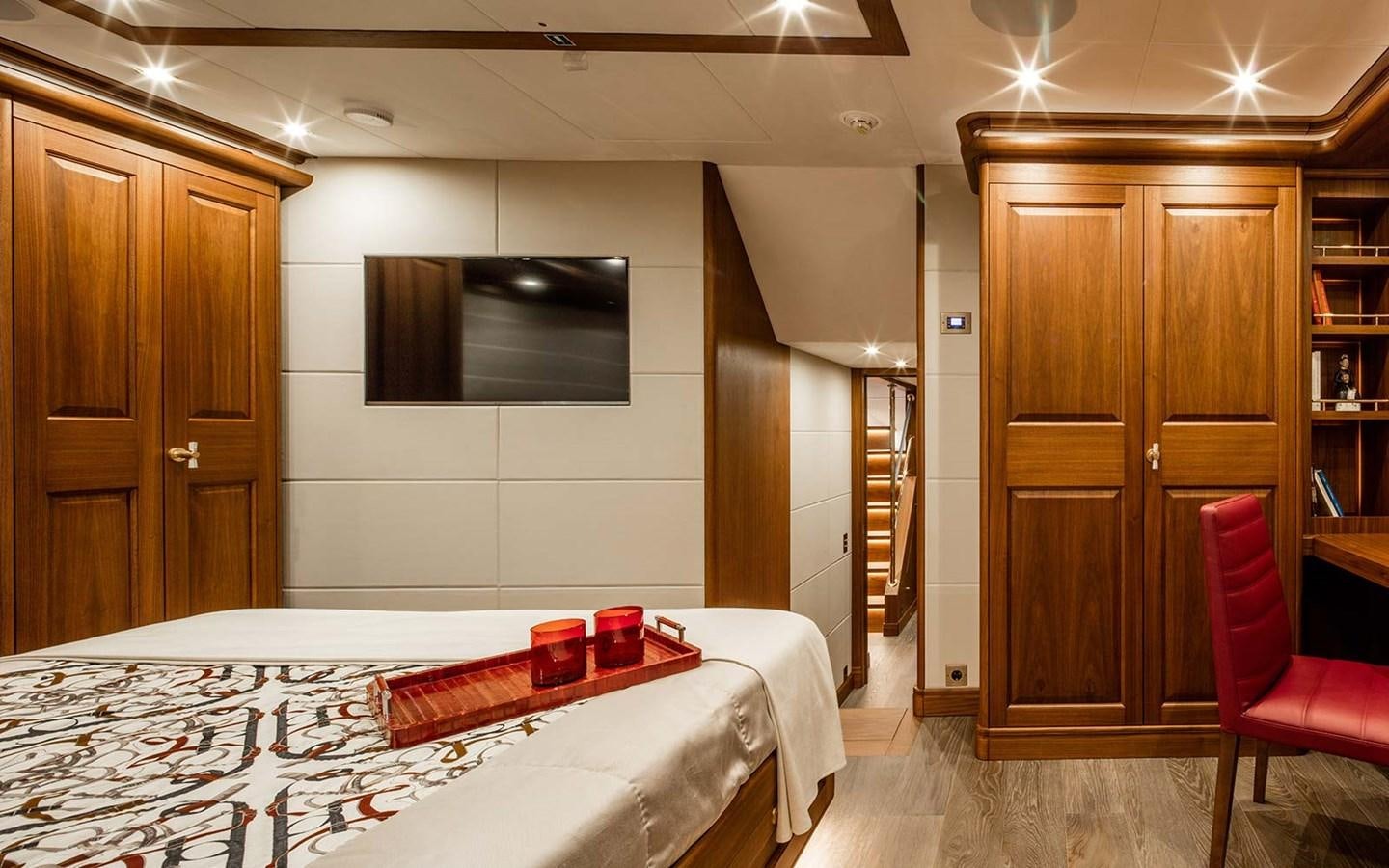 a room with a bed and a television aboard ATLAS Yacht for Sale