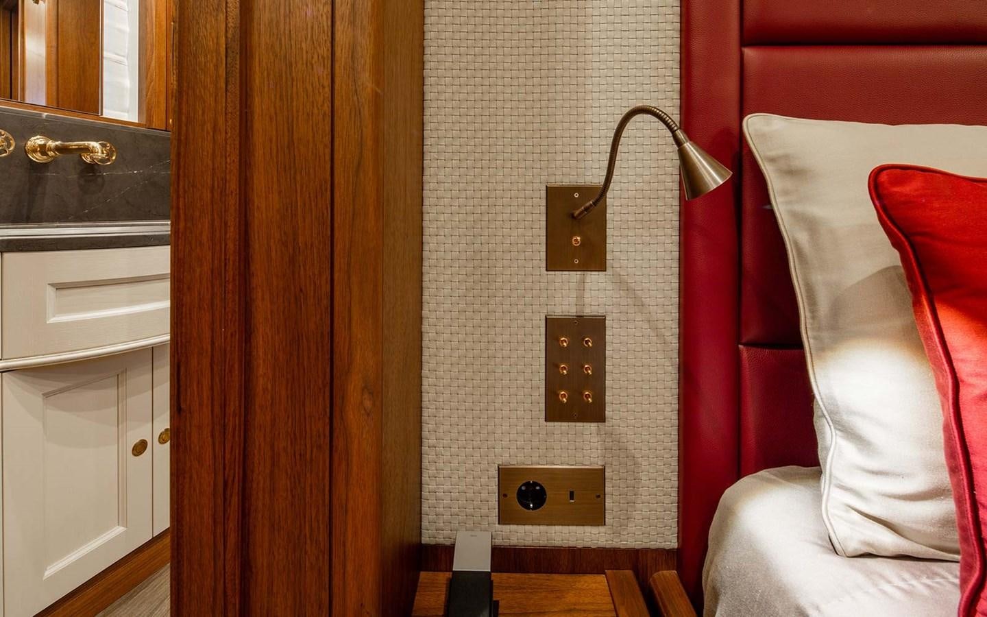 a room with a red couch and a lamp aboard ATLAS Yacht for Sale