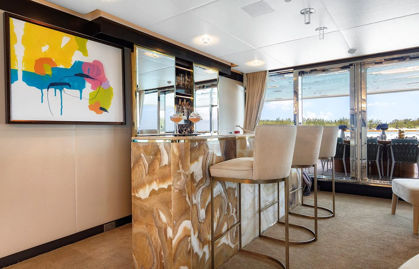 a room with a table chairs and a painting on the wall aboard MYSTIC Yacht for Charter