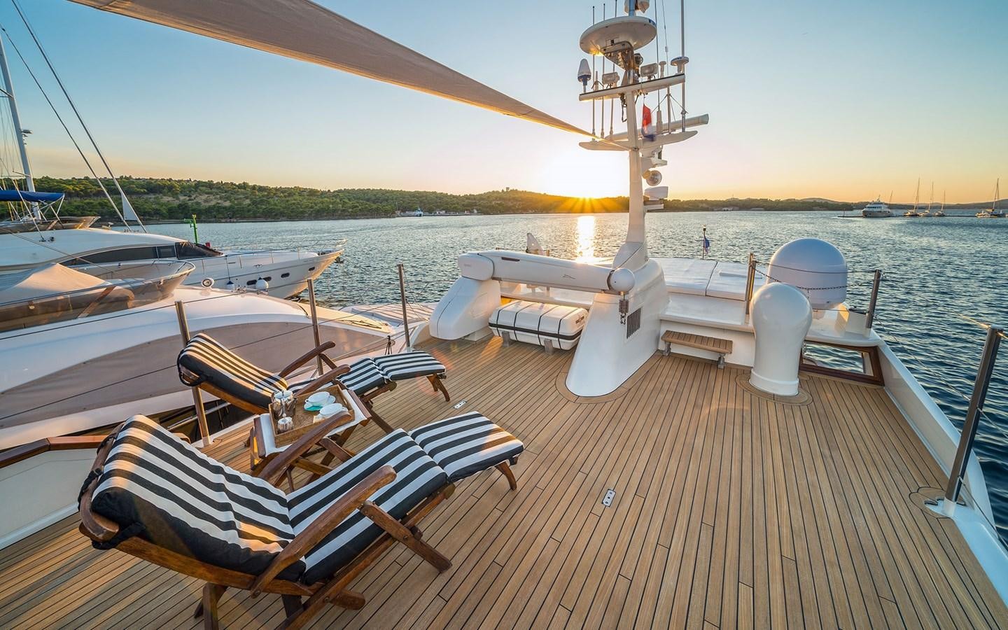 a deck with a boat and chairs on it aboard LACROMA Yacht for Sale