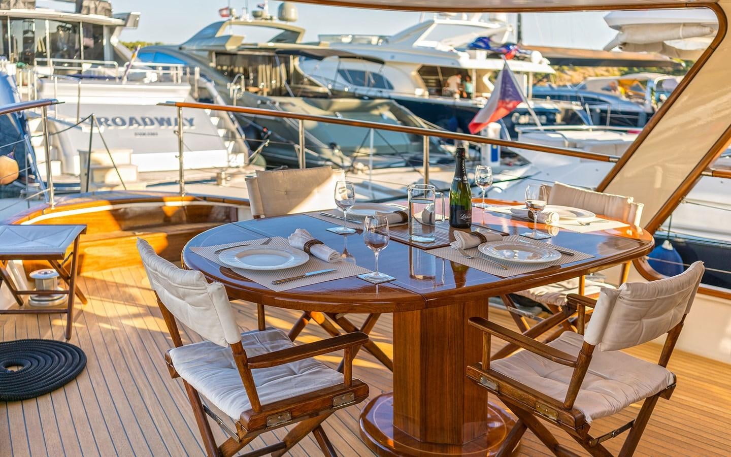 a table with chairs and a plate on it aboard LACROMA Yacht for Sale
