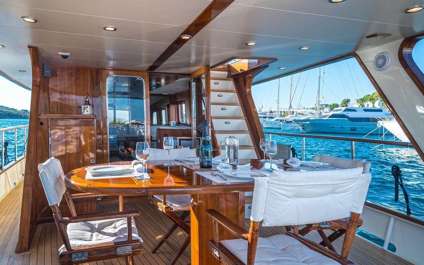 a table with chairs and a glass window on a boat aboard LACROMA Yacht for Sale