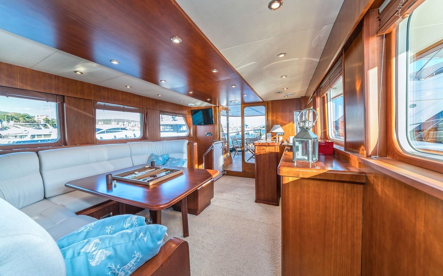 a living room with a couch and a table aboard LACROMA Yacht for Sale