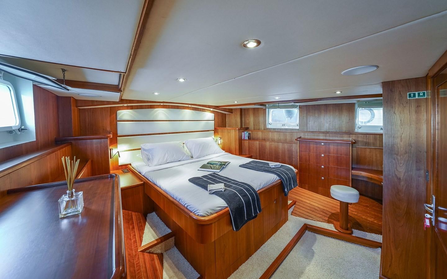 a room with a bed and a table aboard LACROMA Yacht for Sale