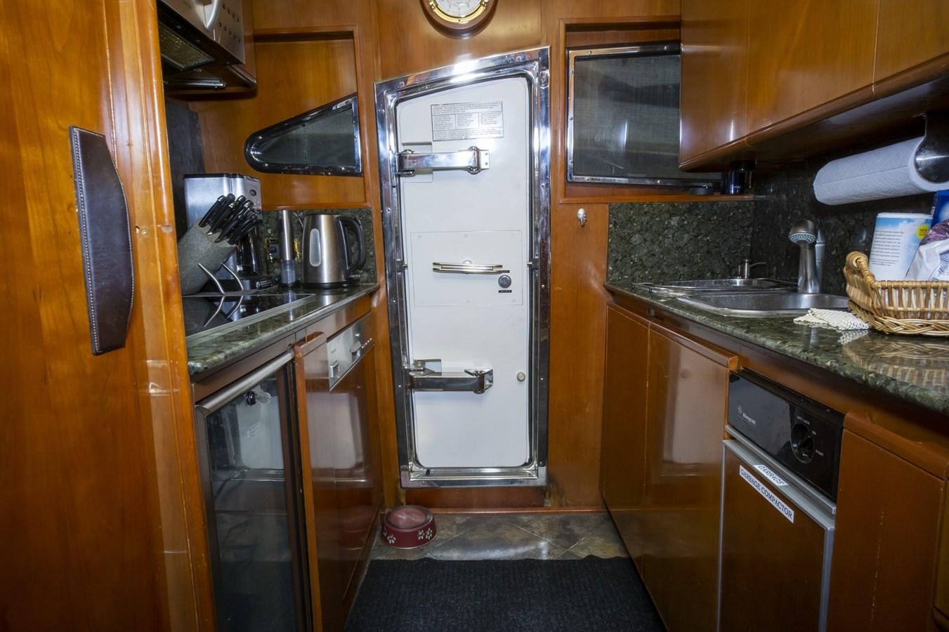 a kitchen with wooden cabinets aboard KARTESSA III Yacht for Sale