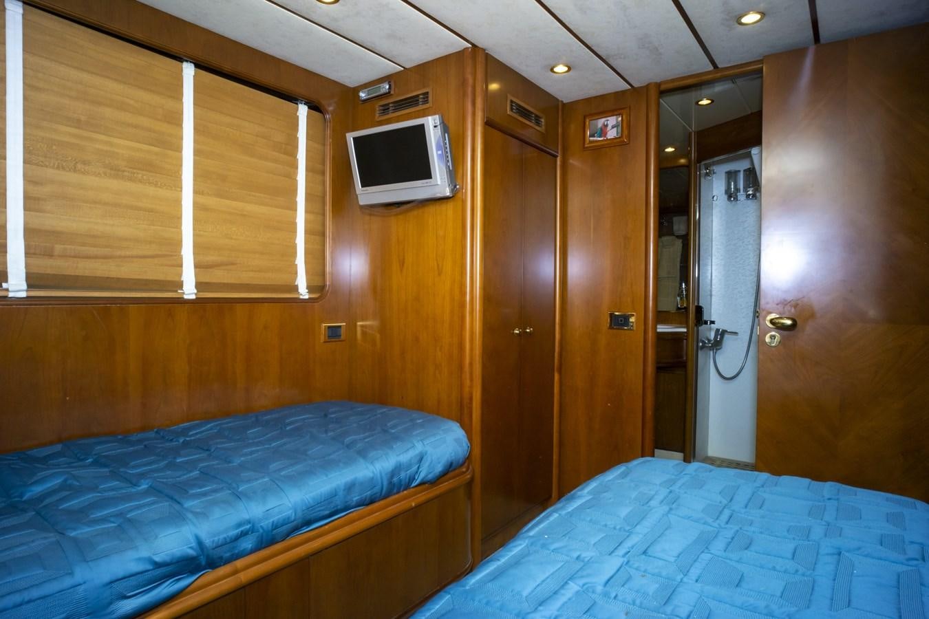 a room with a bed and a television aboard KARTESSA III Yacht for Sale