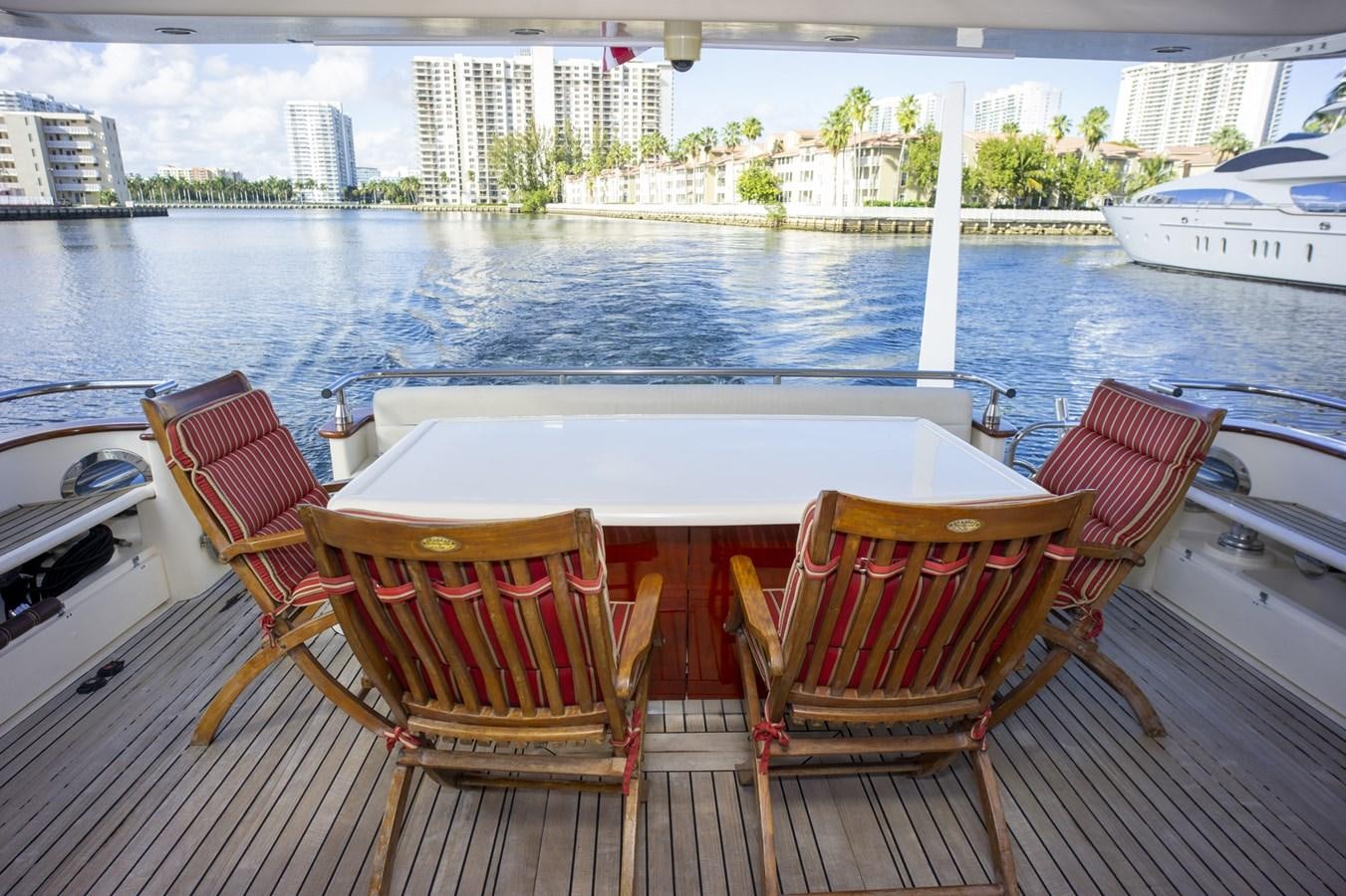 a table and chairs on a deck overlooking a body of water aboard KARTESSA III Yacht for Sale